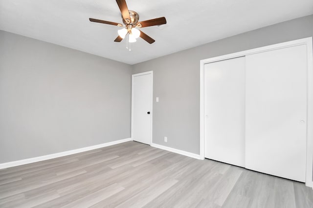 unfurnished bedroom with a closet, light wood-type flooring, and ceiling fan