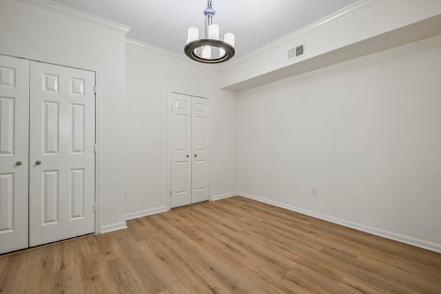 unfurnished bedroom featuring ornamental molding, a chandelier, and light hardwood / wood-style floors