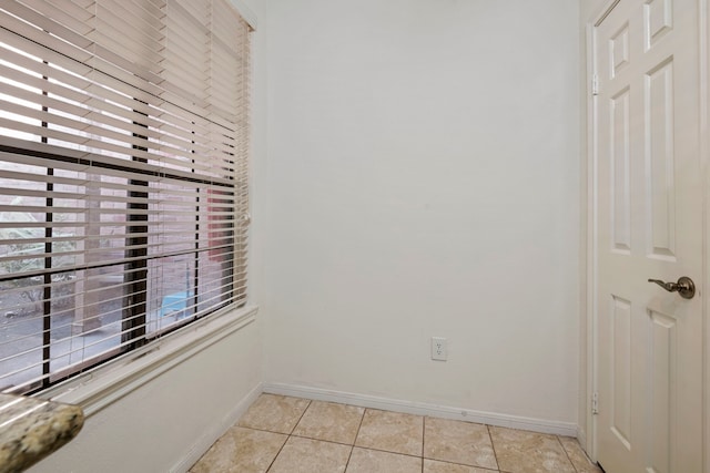 empty room featuring a wealth of natural light and light tile patterned flooring