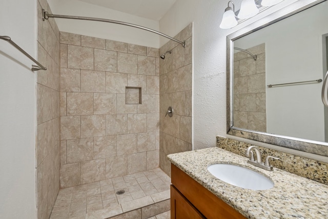 bathroom with vanity and a tile shower