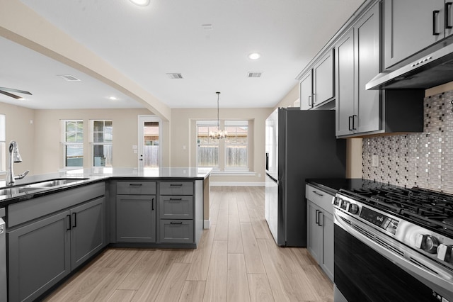 kitchen featuring gray cabinets, tasteful backsplash, sink, range hood, and appliances with stainless steel finishes