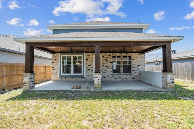 rear view of property with a patio, ceiling fan, and a yard