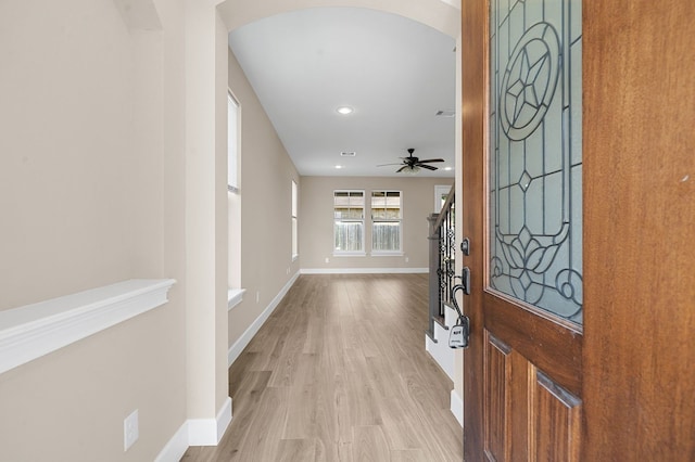 foyer entrance with ceiling fan and light hardwood / wood-style floors