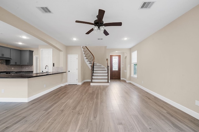 unfurnished living room featuring ceiling fan and light hardwood / wood-style flooring