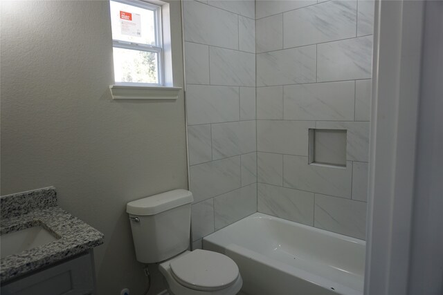 full bathroom featuring vanity, tiled shower / bath combo, and toilet