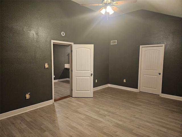 unfurnished bedroom featuring ceiling fan, vaulted ceiling, and hardwood / wood-style floors