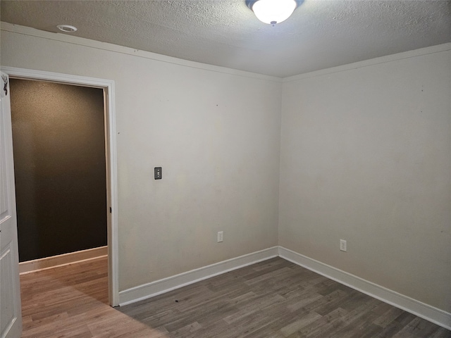 unfurnished room with dark wood-type flooring and a textured ceiling