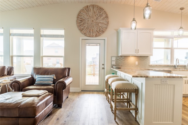 kitchen with a healthy amount of sunlight, pendant lighting, and white cabinets