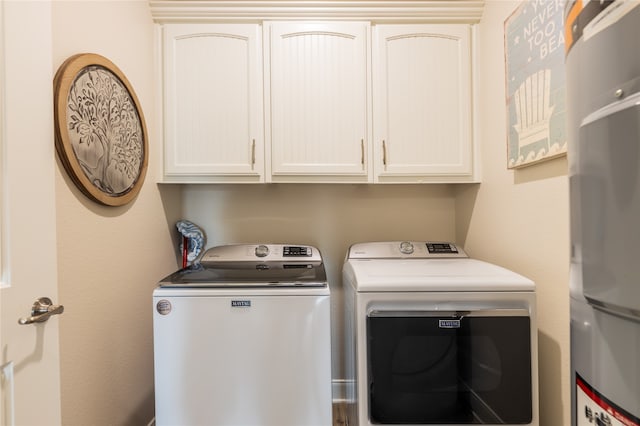 laundry room with cabinets, secured water heater, and washing machine and dryer