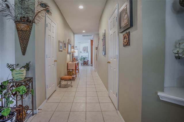 hallway with light tile patterned floors, baseboards, and recessed lighting