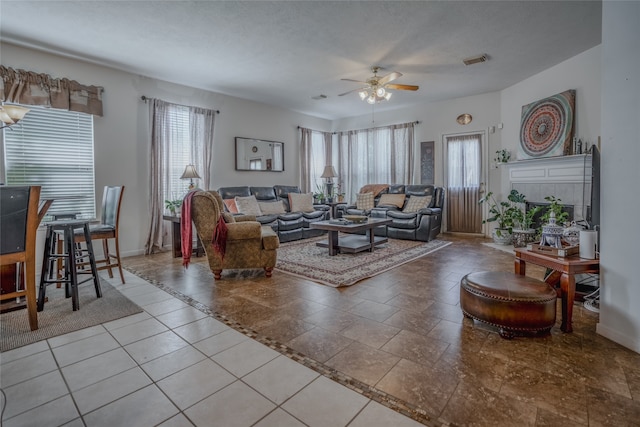 living area with a wealth of natural light, visible vents, a textured ceiling, and baseboards