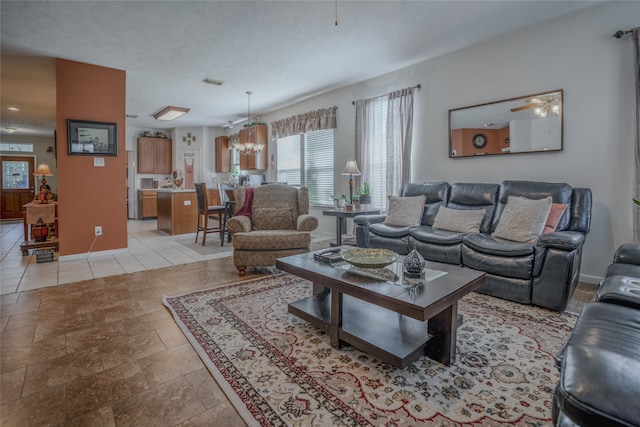 living room featuring ceiling fan with notable chandelier