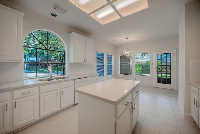 kitchen featuring sink, dishwasher, a kitchen island, decorative light fixtures, and white cabinets