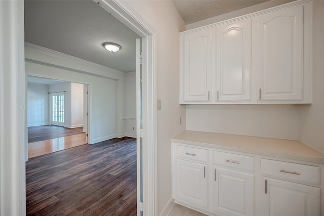 hall with dark wood-type flooring and a textured ceiling