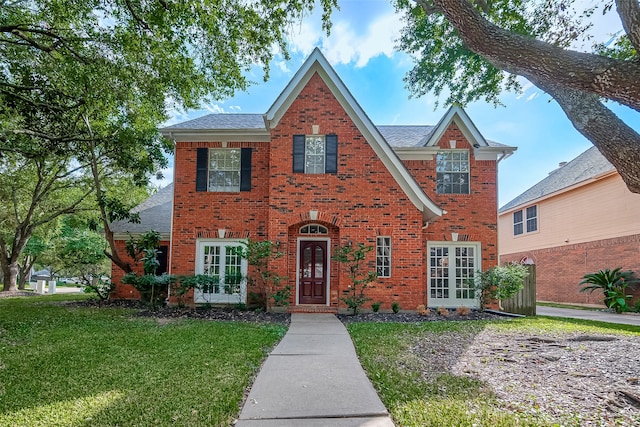 view of front of home with french doors and a front lawn