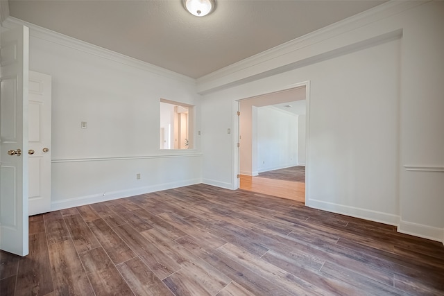 spare room featuring crown molding and wood-type flooring