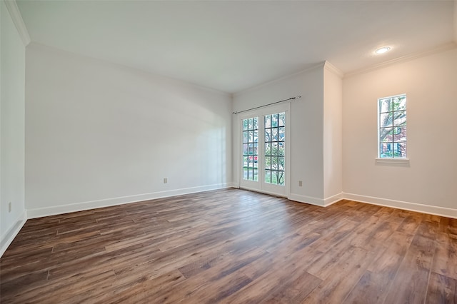 unfurnished room with ornamental molding, a healthy amount of sunlight, and dark hardwood / wood-style flooring