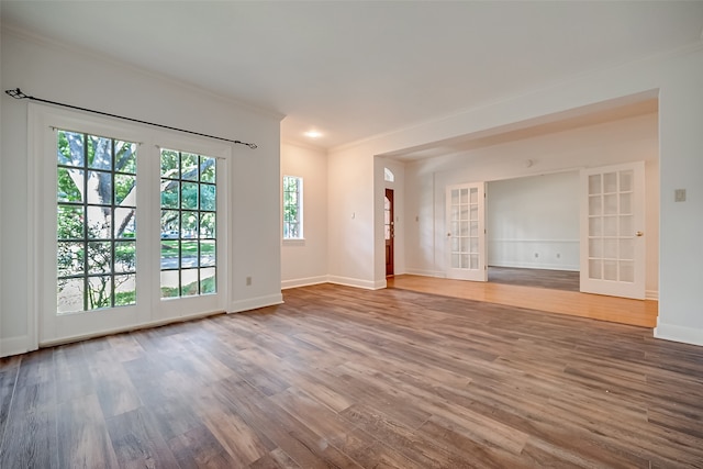 unfurnished room with french doors, crown molding, wood-type flooring, and built in features