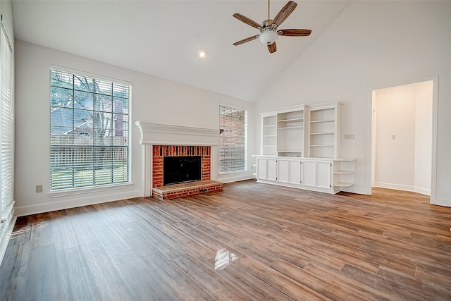 unfurnished living room featuring ceiling fan, high vaulted ceiling, light hardwood / wood-style flooring, and a fireplace