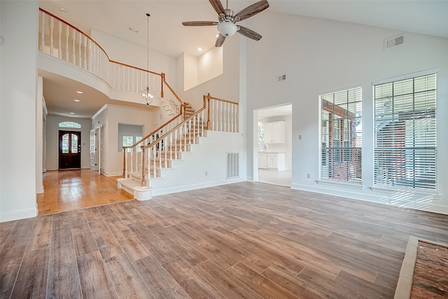 unfurnished living room featuring hardwood / wood-style floors, high vaulted ceiling, and ceiling fan