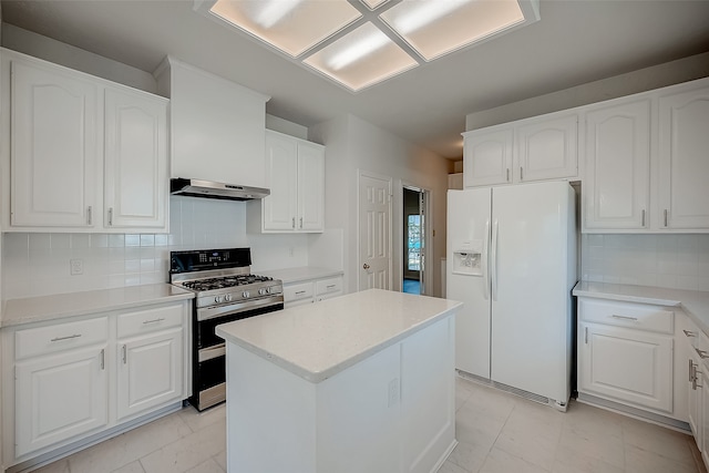 kitchen featuring a kitchen island, white fridge with ice dispenser, white cabinetry, ventilation hood, and stainless steel gas range