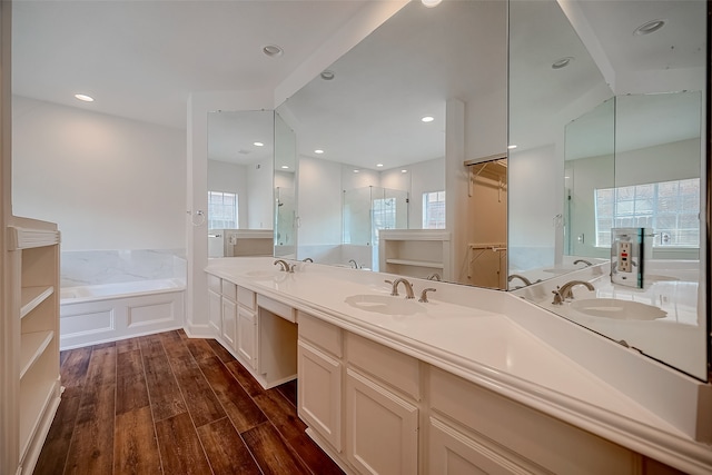 bathroom with vanity, independent shower and bath, and hardwood / wood-style floors