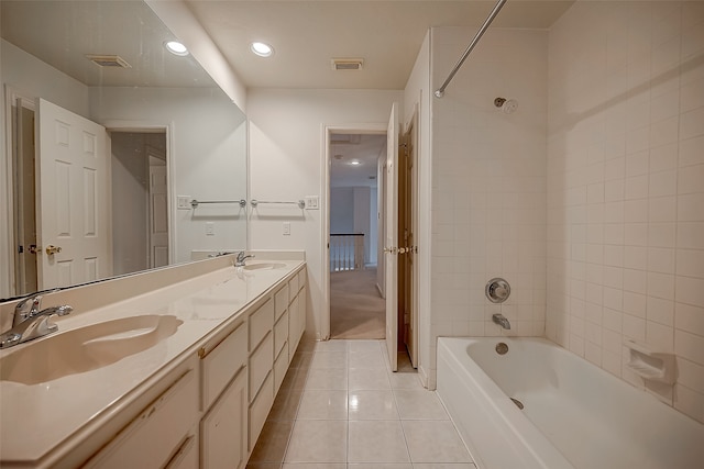 bathroom with vanity, tiled shower / bath combo, and tile patterned flooring