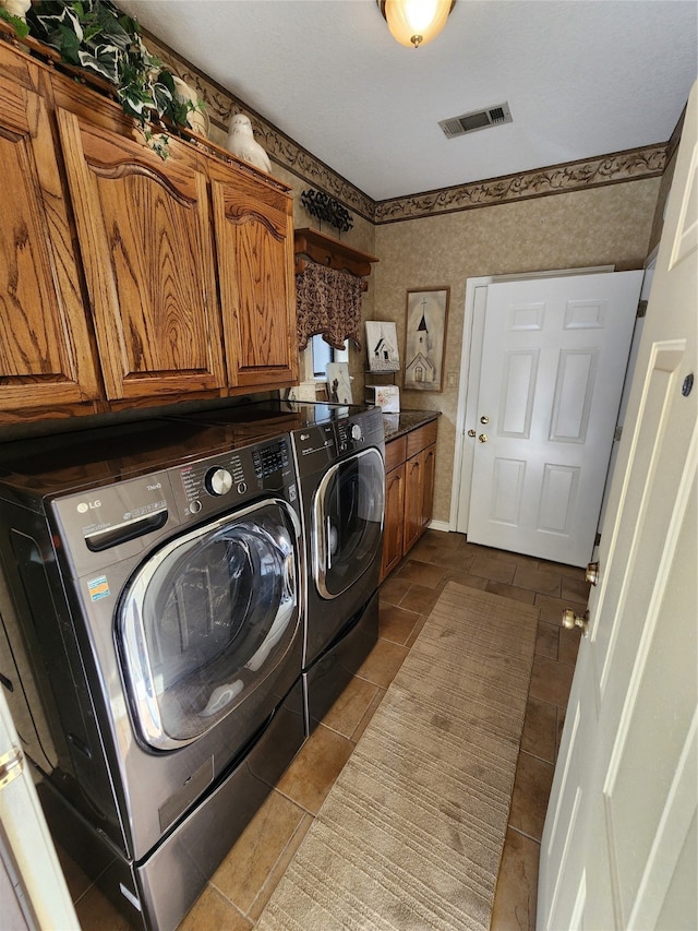 laundry area with cabinets, light tile patterned flooring, and washer and dryer