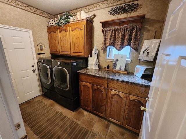 clothes washing area featuring cabinets, a textured ceiling, and independent washer and dryer