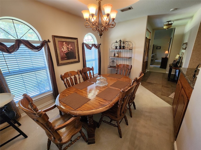 dining area with an inviting chandelier, a wealth of natural light, and light colored carpet