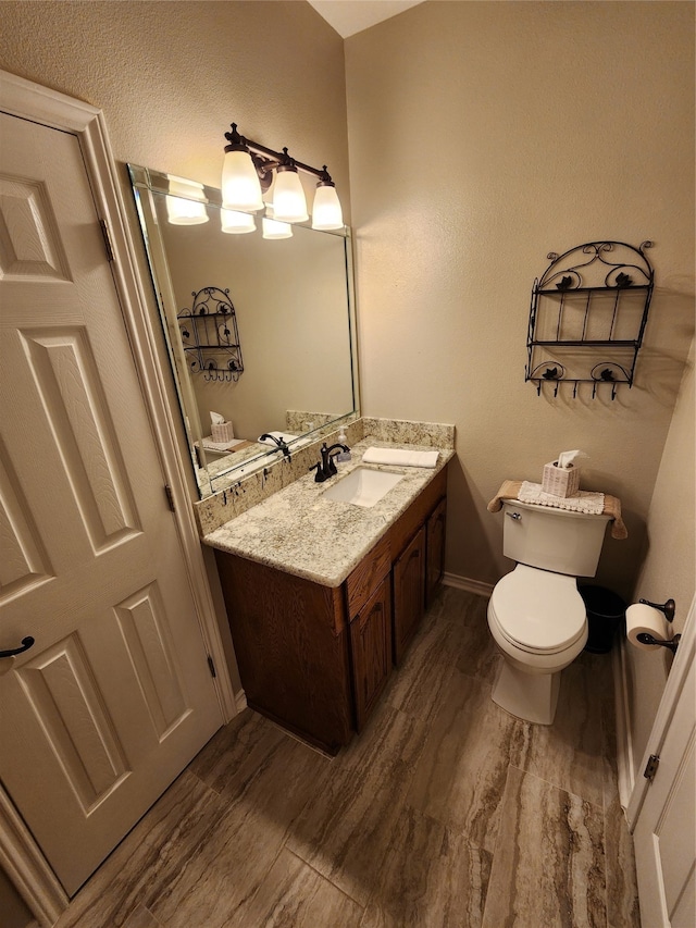 bathroom featuring wood-type flooring, vanity, and toilet