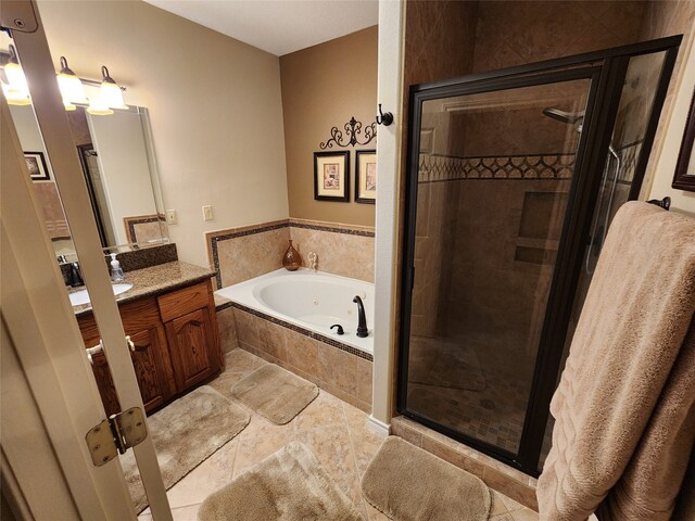 bathroom with tile patterned floors, independent shower and bath, and vanity