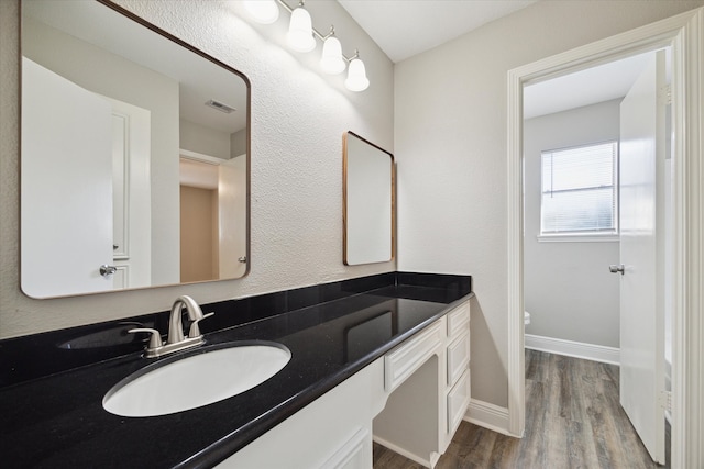 bathroom featuring vanity, toilet, and hardwood / wood-style floors