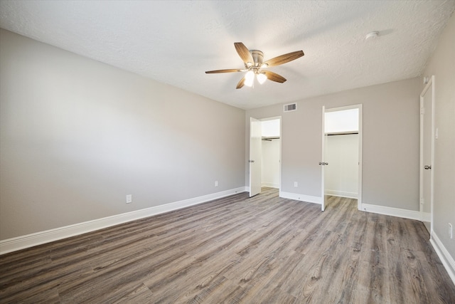 unfurnished bedroom featuring a closet, ceiling fan, a textured ceiling, and hardwood / wood-style floors