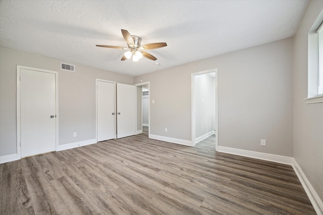 unfurnished bedroom featuring a textured ceiling, hardwood / wood-style flooring, and ceiling fan