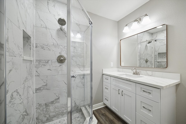 bathroom featuring a shower with door, vanity, and wood-type flooring