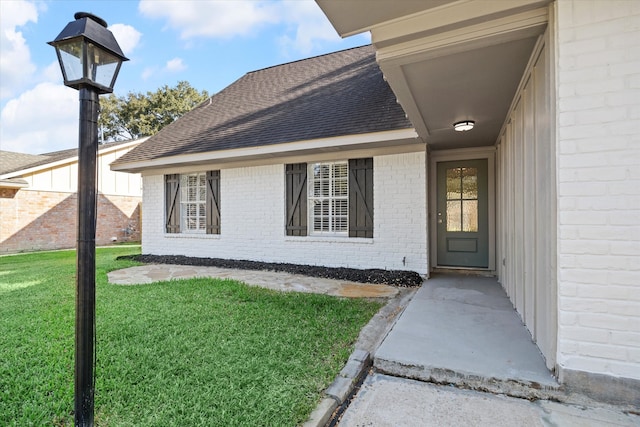 doorway to property with a lawn