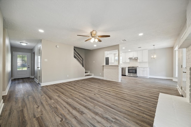 unfurnished living room featuring a textured ceiling, dark hardwood / wood-style floors, and ceiling fan