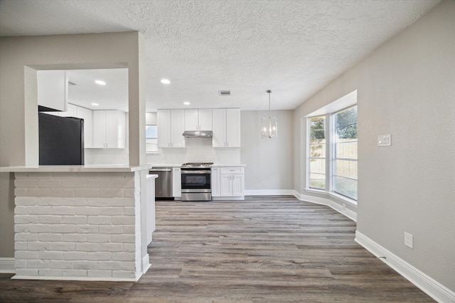 kitchen featuring appliances with stainless steel finishes, kitchen peninsula, wood-type flooring, and white cabinets