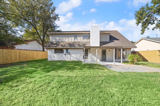 back of property with a patio area and a lawn