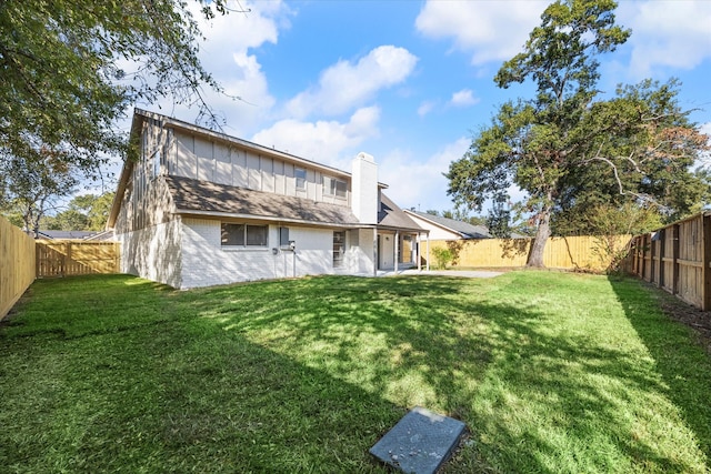 back of house featuring a lawn