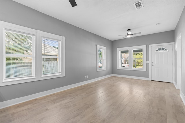 interior space featuring ceiling fan, light hardwood / wood-style flooring, and a healthy amount of sunlight