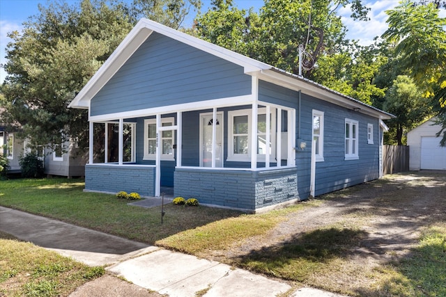 bungalow featuring a sunroom and a front lawn