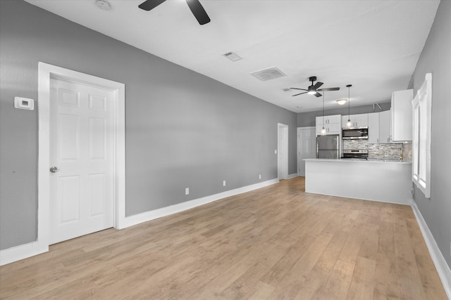 unfurnished living room with light wood-type flooring and ceiling fan