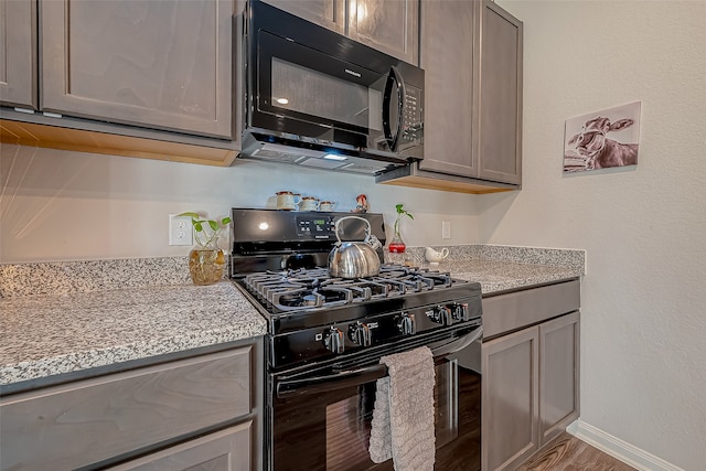 kitchen with black appliances and wood-type flooring