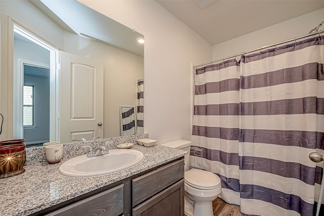 bathroom featuring walk in shower, vanity, hardwood / wood-style floors, and toilet