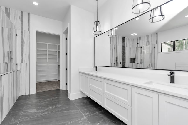 bathroom featuring a shower with shower door and vanity