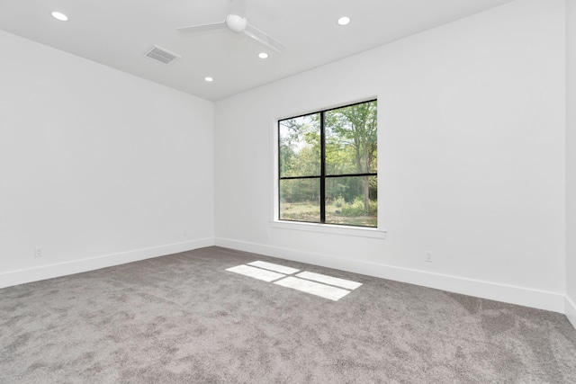 empty room featuring ceiling fan and carpet