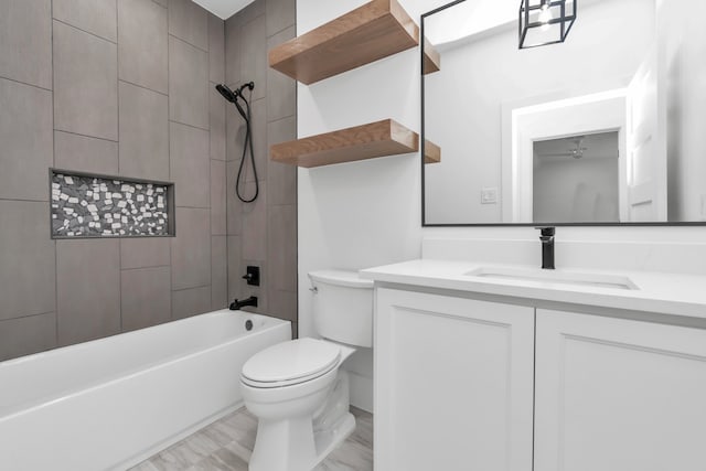 full bathroom featuring vanity, tiled shower / bath combo, and toilet