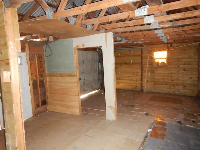 basement featuring wooden walls